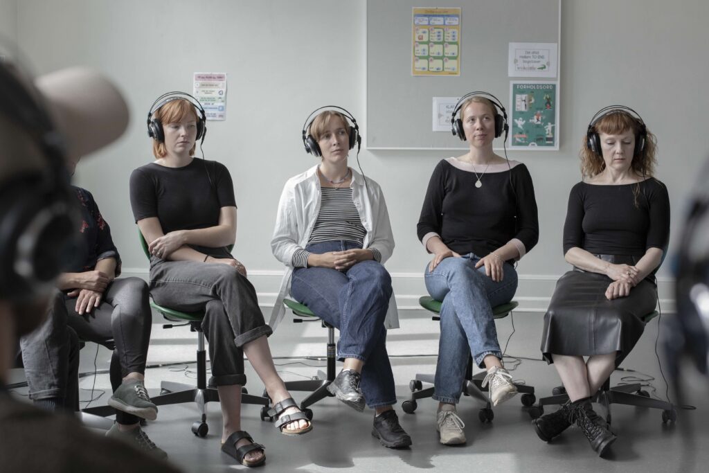 people listening with headphones next to each other